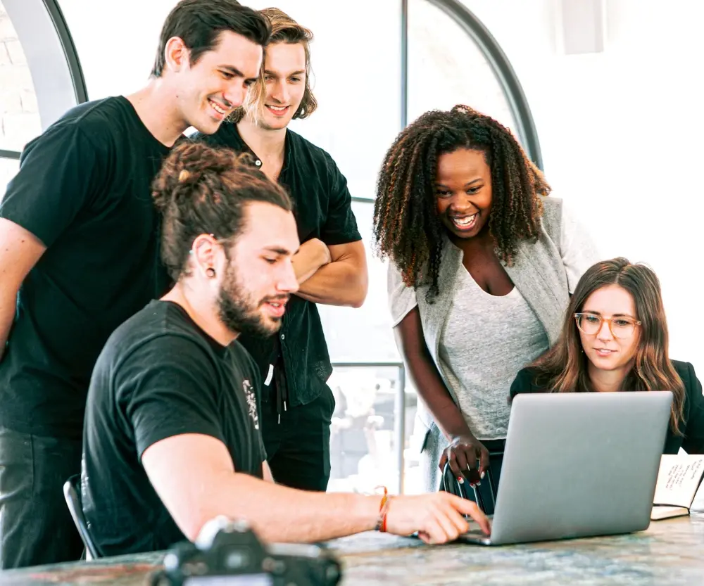 A team of colleagues looking a laptop