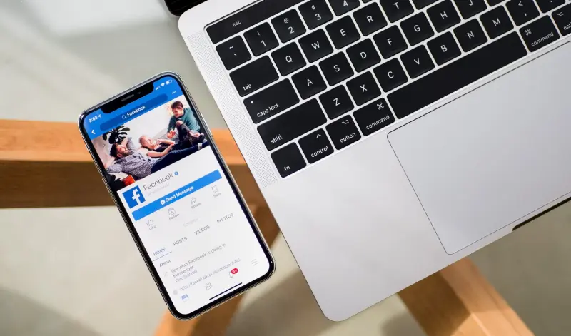 Το iPhone X εμφανίζει την εφαρμογή Facebook δίπλα σε ένα MacBook